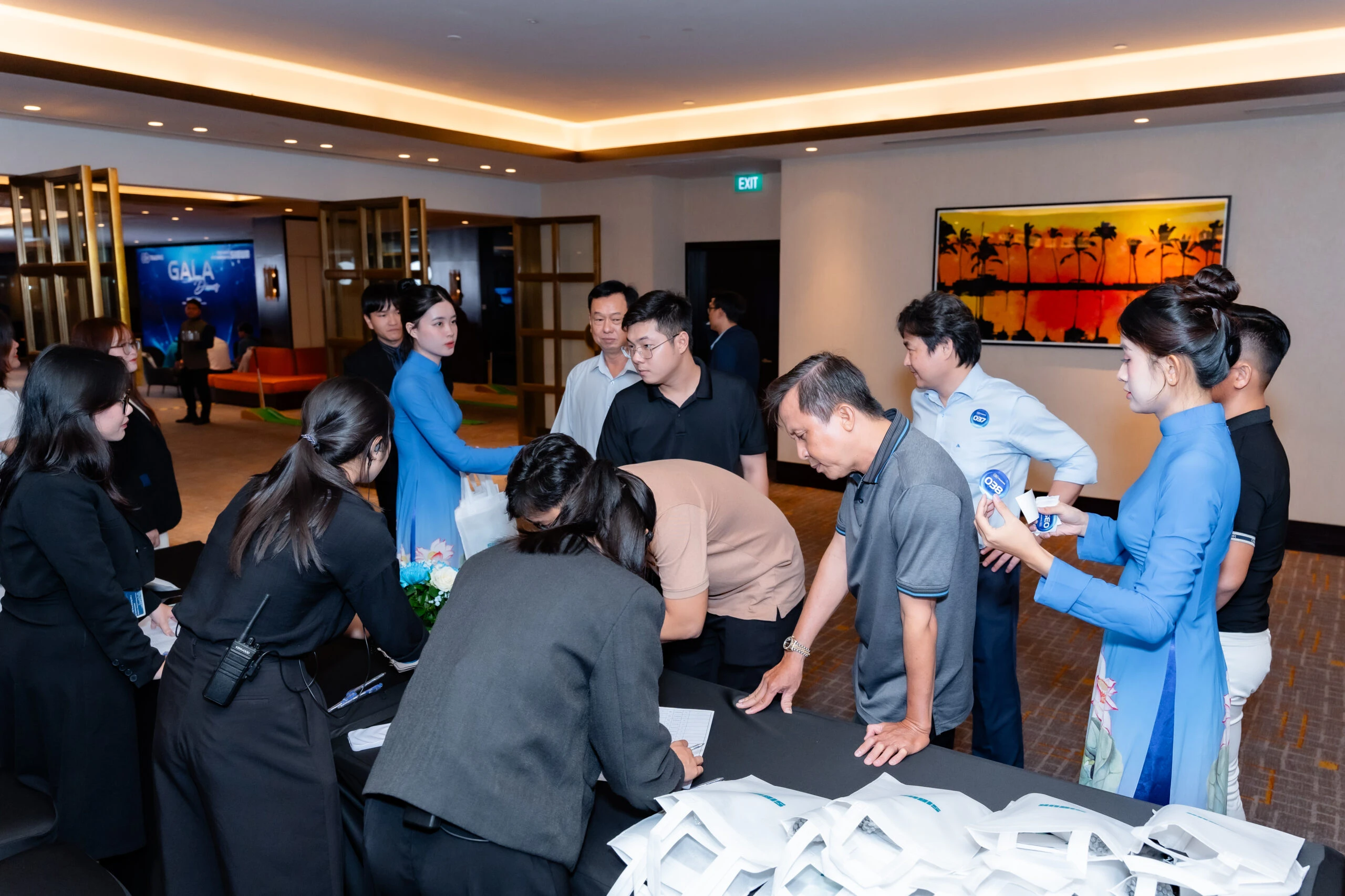 Khách mời check in tại sự kiện doanh nghiệp với khu vực lễ tân và backdrop thương hiệu