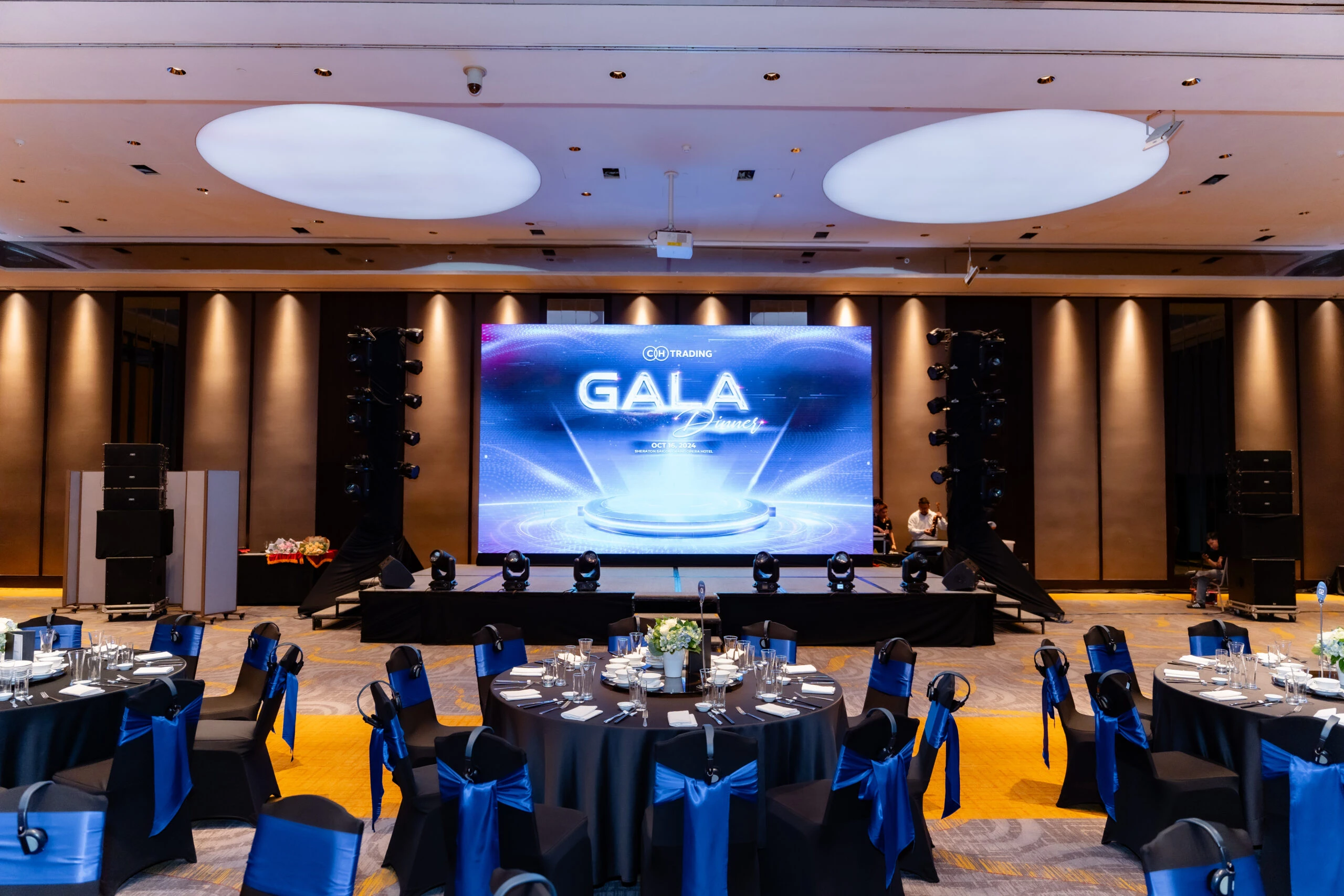 Không gian ballroom doanh nghiệp với sân khấu LED và bàn tiệc cho sự kiện công ty